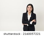 Young asian business woman smiling to camera standing pose on isolated white background. Female around 25 in suit portrait shot in studio.