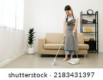 Housewife using broom and...