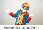 Small photo of Laughing Mr Clown. Portrait of Funny happy face comedian Clown man in colorful costume wearing wig listen music. Happy expression amazed bozo dancing with music in various pose on white background.