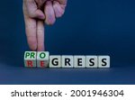 Small photo of Regress or progress symbol. Businessman turns wooden cubes and changes the word 'regress' to 'progress'. Beautiful grey table, grey background, copy space. Business, regress or progress concept.