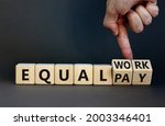 Small photo of Equal pay and work symbol. Businessman turns wooden cubes and changes words equal pay to equal work. Beautiful grey background. Copy space. Business and equal pay and work concept.