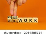 Small photo of Hybrid or office work symbol. Businessman turns cubes and changes words 'office work' to 'hybrid work'. Beautiful orange background. Business, hybrid or office working concept, copy space.