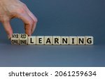 Small photo of Online or hybrid learning symbol. Businessman turns cubes, changes words online learning to hybrid learning. Grey background. Business, educational and online or hybrid learning concept. Copy space.