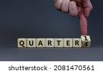 Small photo of From 4th to 1st quarter symbol. Businessman turns a cube and changes words 'quarter 4' to 'quarter 1'. Beautiful grey table, grey background. Business, happy 1st quarter concept, copy space.