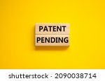 Small photo of Time to patent pending symbol. Concept words Patent pending on wooden blocks on a beautiful yellow background. Business and patent pending concept. Copy space.