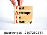 Small photo of FAIL first attempt in learning symbol. Wooden blocks with words FAIL first attempt in learning. Beautiful white table, white background, copy space. Business, FAIL first attempt in learning concept.