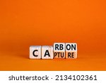 Carbon capture symbol. Turned wooden cubes and changed the concept word Carbon to Capture. Beautiful orange table orange background. Business ecological carbon capture concept. Copy space.