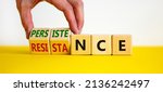 Small photo of Persistence or resistance symbol. Businessman turns cubes, changes the word 'resistance' to 'persistence'. Beautiful white background. Copy space. Business and persistence or resistance concept.