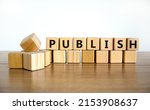 Small photo of Publish symbol. The concept word Publish on wooden cubes. Beautiful wooden table, white background, copy space. Business publish and publishing concept.