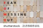 Small photo of FOMO fear of missing out symbol. Concept words FOMO fear of missing out on wooden blocks on beautiful wooden background. Business FOMO fear of missing out concept. Copy space.