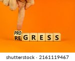 Small photo of Regress or progress symbol. Businessman turns wooden cubes and changes the word Regress to Progress. Beautiful orange table orange background. Business regress or progress concept. Copy space.