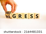 Small photo of Regress or progress symbol. Businessman turns wooden cubes and changes the word Regress to Progress. Beautiful white table white background. Business regress or progress concept. Copy space.