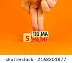 Small photo of Stigma or shame symbol. Concept words Stigma or Shame on wooden cubes. Businessman hand. Beautiful orange table orange background. Business stigma or shame concept. Copy space.