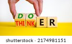Small photo of Doer or thinker symbol. Concept words Doer or thinker on wooden cubes. Businessman hand. Beautiful yellow table white background. Business and doer or thinker concept. Copy space.