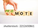 Small photo of Promote or demote symbol. Businessman turns cubes and changes the word 'demote' to 'promote'. Beautiful white background. Business, demote or promote concept. Copy space.