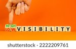 Small photo of High or low visibility symbol. Concept words High visibility and Low visibility on wooden cubes. Businessman hand. Beautiful orange background. Business high or low visibility concept. Copy space.