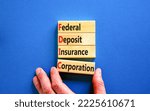 Small photo of FDIC federal deposit insurance corporation symbol. Concept words FDIC federal deposit insurance corporation on blocks on blue background. Business FDIC federal deposit insurance corporation concept.