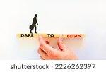 Small photo of Dare to begin symbol. Wooden blocks with words 'Dare to begin'. Beautiful white background, businessman hand, businessman icon. Business, dare to begin concept, copy space.