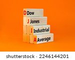 Small photo of DJIA Dow Jones industrial average symbol. Concept words DJIA Dow Jones industrial average on wooden block on beautiful orange background. Business DJIA Dow Jones industrial average concept. Copy space
