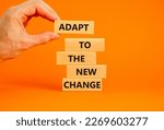 Small photo of Adapt to the new change symbol. Wooden blocks with words Adapt to the new change on orange background, copy space. Businessman hand. Business, adapt to change concept.