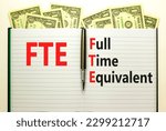 Small photo of FTE Full time equivalent symbol. Concept words FTE Full time equivalent on white note. Dollar bills. Beautiful white table white background. Business and FTE Full time equivalent concept. Copy space.