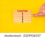 Small photo of Time to chapter 2 symbol. Concept word Chapter 1 2 3 4 5 on wooden sticks. Businessman hand. Beautiful yellow table yellow background. Business planning and time to chapter 2 concept. Copy space.