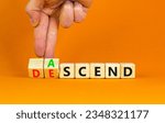Small photo of Ascend or descend symbol. Concept words Ascend and Descend on wooden cubes. Beautiful orange table orange background. Businessman hand. Business ascend or descend concept. Copy space.