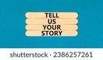Small photo of Tell us your story symbol. Concept word Tell us your story on beautiful wooden stick. Beautiful blue table blue background. Business tell us your story concept. Copy space.