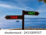Small photo of Fact or fake symbol. Concept word Fake and Fact on beautiful signpost with two arrows. Beautiful blue sea sky with clouds background. Business and fact or fake concept. Copy space.