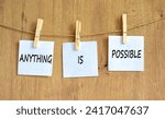 Small photo of Anything is possible symbol. Concept words Anything is possible on beautiful white paper on clothespin. Beautiful wooden table wooden background. Business anything is possible concept. Copy space.