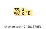 Small photo of Fake or true symbol. Turned wooden cubes and changed the word fake to true or vice versa. Beautiful white table, white background, copy space. Business and fake or true concept.