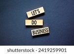 Small photo of let is do business symbol. Concept words let is do business on beautiful wooden blocks. Beautiful black table black background. let is do business concept. Copy space.