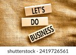 Small photo of let is do business symbol. Concept words let is do business on beautiful wooden blocks. Beautiful canvas table canvas background. let is do business concept. Copy space.