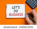 Small photo of let is do business symbol. Concept words let is do business on beautiful white note. Beautiful orange background. Businessman hand. Calculator. let is do business concept. Copy space.
