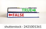 Small photo of True or false symbol. Concept word True or False on beautiful books. Beautiful white table white background. Business and true or false concept. Copy space.