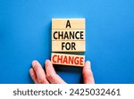 Small photo of A chance for change symbol. Concept words A chance for change on beautiful wooden block. Beautiful blue table blue background. Voter hand. Business A chance for change concept. Copy space.