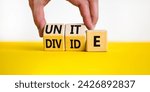 Small photo of Unite or divide symbol. Concept word Unite or Divide on wooden cubes. Beautiful yellow table white background. Businessman hand. Business unite or divide concept. Copy space.