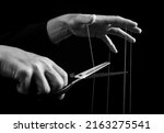 Small photo of Man cutting strings on hands with scissors. Abuse, violence, slavery cessation. Overcoming addiction and mental health problems. Getting rid of manipulation. Black and white. High quality photo