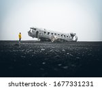 Solheimasandur Plane Wreck in Iceland with person wearing yellow jacket.