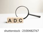 Small photo of Lettering ADC on wooden cubes on a gray background