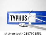 Small photo of typhus word on file folder and stethoscope on white background