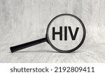 Small photo of Magnifying lens with text acronym word inscription HIV human immunodeficiency virus