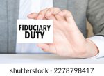 Small photo of man's hand holding paper sheet with fiduciary duty words
