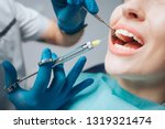 Small photo of Close up of dentist's hands holding tool and syringe in hands. Pain killer in action. Female client keep mouth opened. Beautiful smile and white teeth. Cut view.