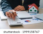 Small photo of House plans with real estate agents and clients calculating the first lump sum for a home purchase contract, insurance or real estate loan