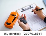 Small photo of Insurance officers hand over the car keys after the tenant. have signed an auto insurance document or a lease or agreement document Buying or selling a new or used car with a car