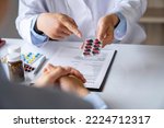 doctor or pharmacist advises patients about pills. The doctor prescribes medication sitting at a table in the clinic office. to find the best course of treatment. follow-up treatment