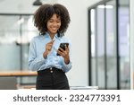 Young african american businesswoman sitting on the desk at the office while making a video call with a business colleague in receiving good news on modern business contracts.