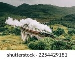 Jacobite steam train crossing the Glenfinnan Viaduct with steam rising from the chimney. Hogwarts Express, Harry Potter.