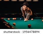 A girl in a hat in a billiard...